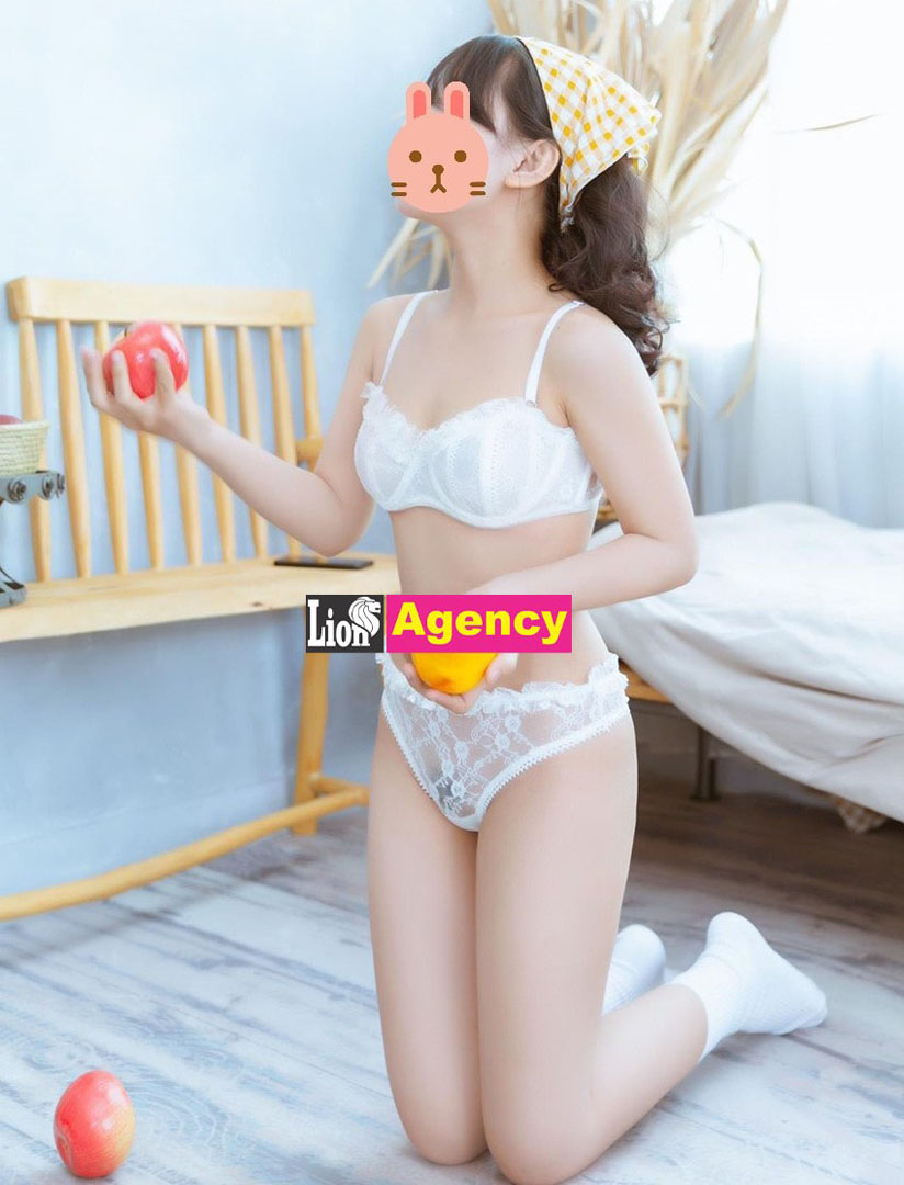 A 707 escort girl in white lingerie seductively holding an apple.