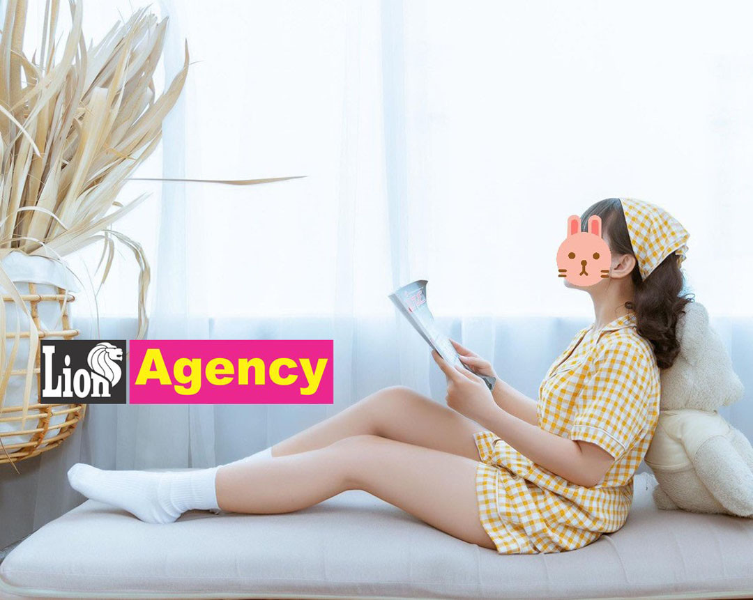 A girl is sitting on a bed reading a book in 707.