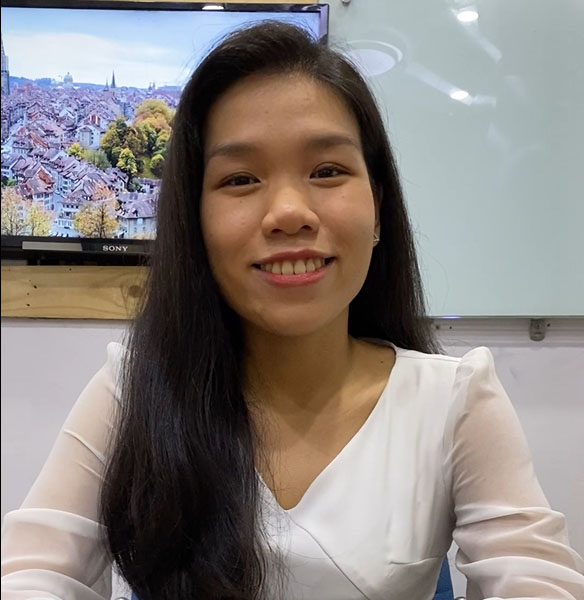 An **escort kl** smiling in front of a tv.