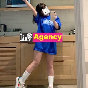 A 707 escort, wearing a blue shirt, is posing in front of a mirror.