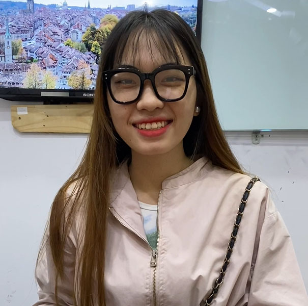 A stylish young woman, sporting glasses and a fashionable pink jacket, offers the best escort services in Kuala Lumpur as an elite KL escort girl.