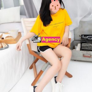 A 707 sitting on a chair wearing a yellow t-shirt.