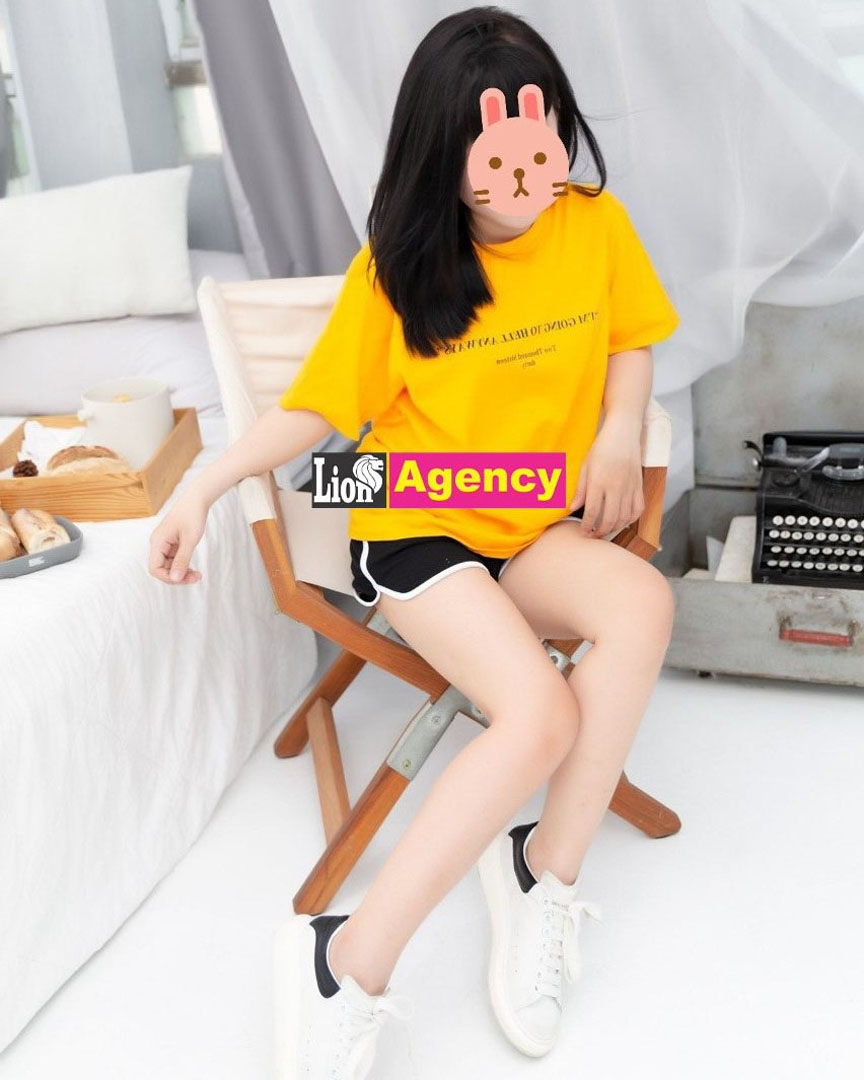 A 707 sitting on a chair wearing a yellow t-shirt.