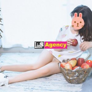 A girl sitting on the floor with a 707 of apples.