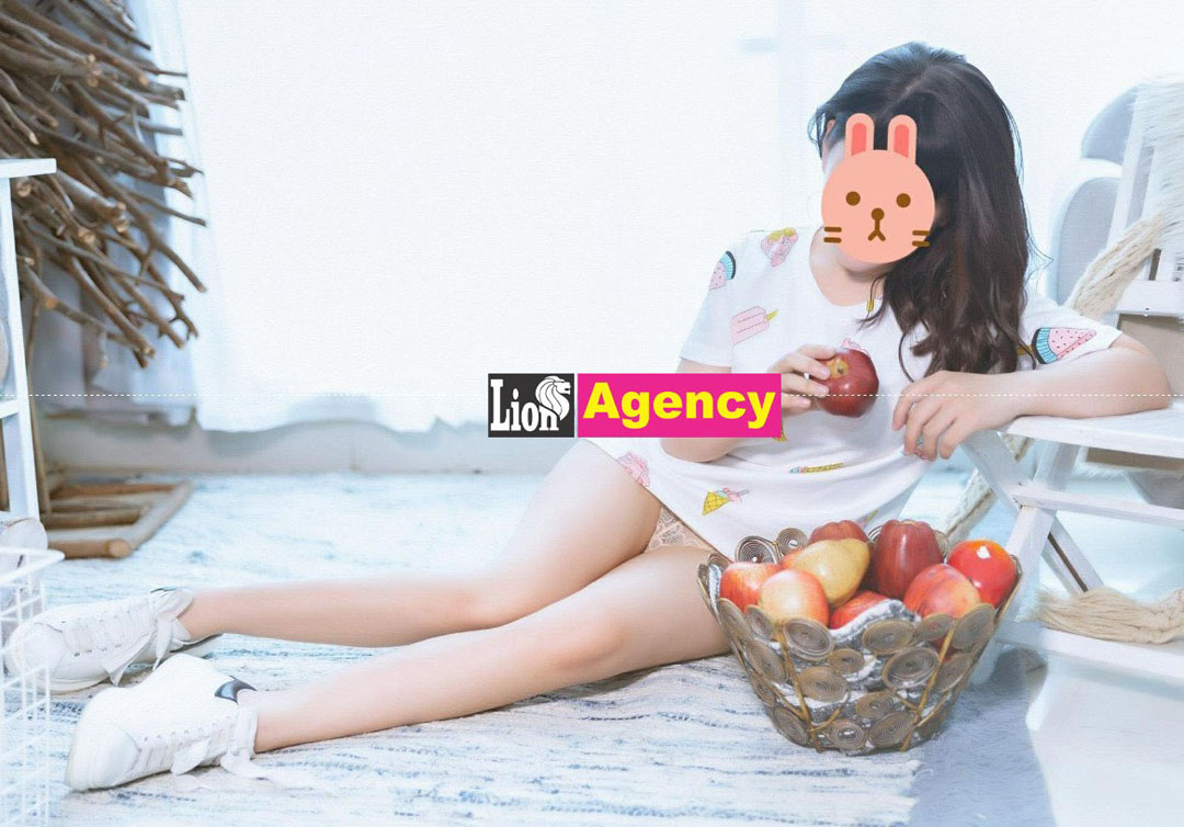 A girl sitting on the floor with a 707 of apples.