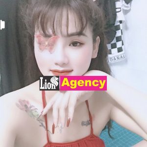 A kl escort girl with tattoos and a red dress is posing for a photo.