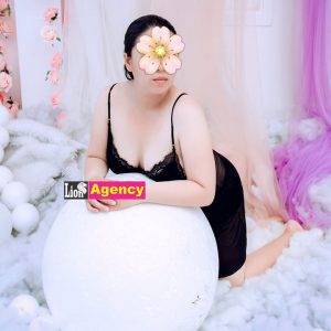 A woman is elegantly posing in front of a white 540 filled with flowers in Kuala Lumpur.