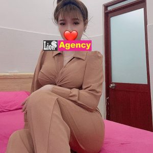 An elegant escort wearing the 681 sensually posing on a luxurious bed in KL.