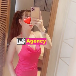 A woman in a pink dress capturing a selfie with the 681 in a mirror.