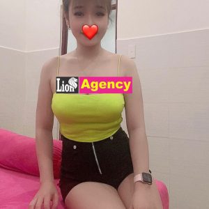 A young woman with a 681 on her face posing on a bed in KL.