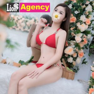 A woman in a red bikini posing amongst vibrant flowers named 279.